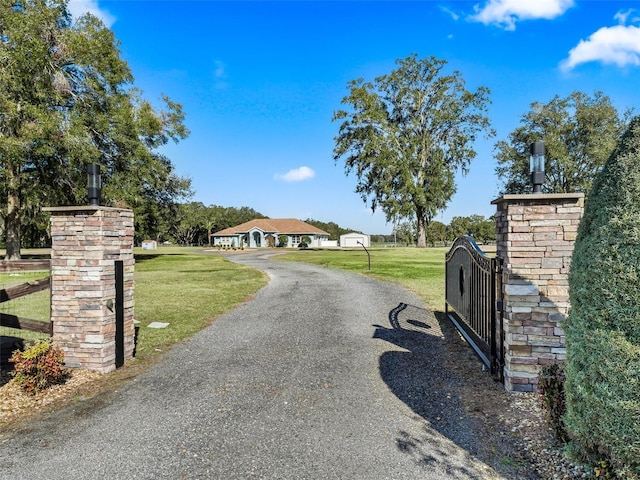 view of road with aphalt driveway, a gated entry, and a gate