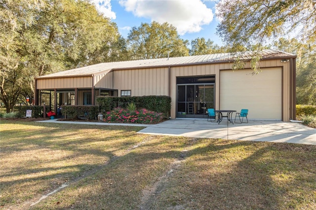 back of house with a patio and a lawn