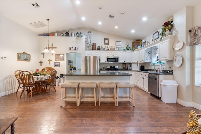 kitchen featuring appliances with stainless steel finishes, dark hardwood / wood-style floors, decorative light fixtures, white cabinetry, and sink