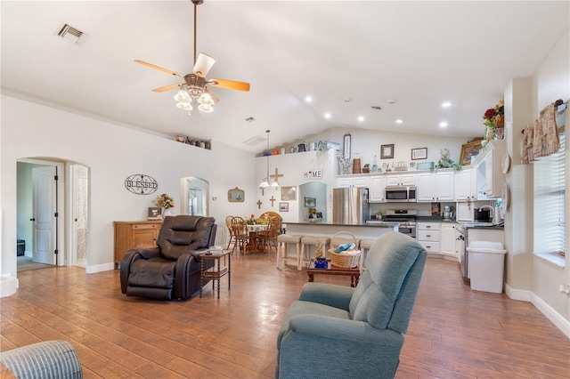 living room featuring ceiling fan, wood-type flooring, and vaulted ceiling