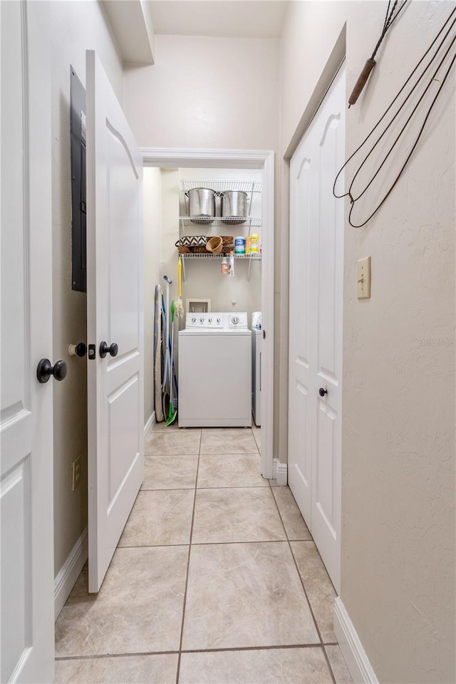 washroom with electric panel, washer and dryer, and light tile patterned floors