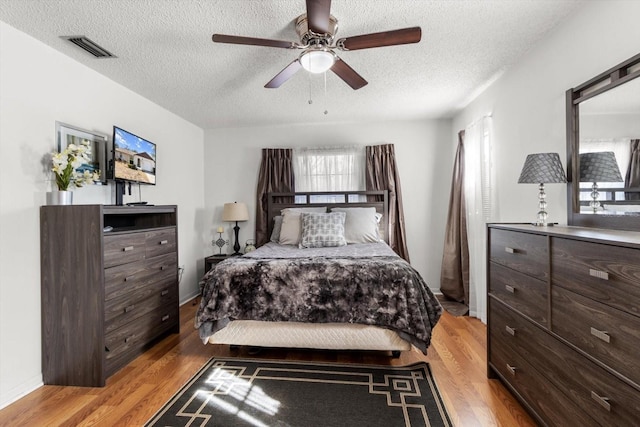 5570 W Cagney Loop, Homosassa, FL 34448 - bedroom with light wood finished floors, a textured ceiling, and ceiling fan
