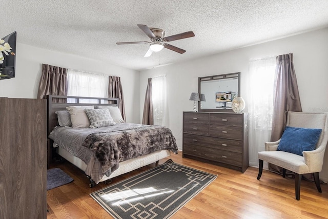 5570 W Cagney Loop, Homosassa, FL 34448 - bedroom with light wood-style flooring, a textured ceiling, and ceiling fan