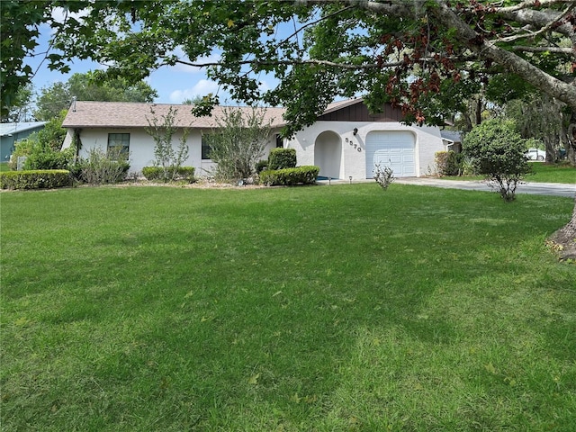 5570 W Cagney Loop, Homosassa, FL 34448 - ranch-style house featuring a front yard, concrete driveway, a garage, and stucco siding