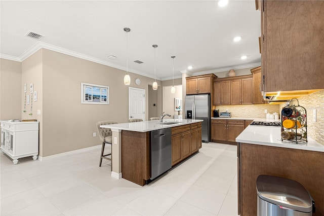 kitchen featuring an island with sink, backsplash, hanging light fixtures, stainless steel appliances, and crown molding