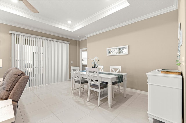 dining area with light tile patterned floors, a tray ceiling, ornamental molding, and ceiling fan