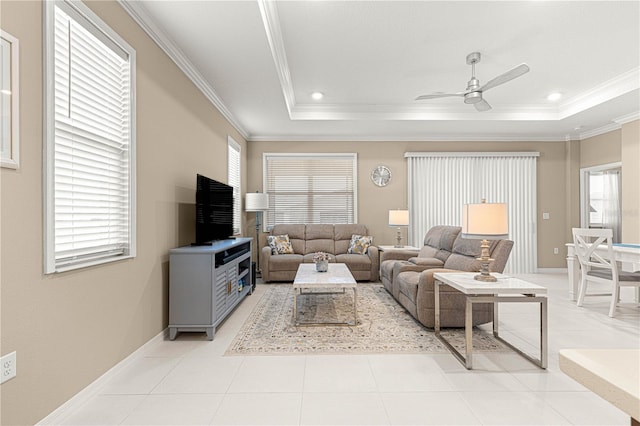 living room with ornamental molding, a raised ceiling, ceiling fan, and light tile patterned flooring