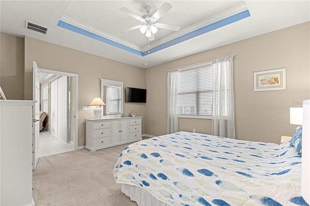 carpeted bedroom with crown molding, a textured ceiling, a raised ceiling, and ceiling fan