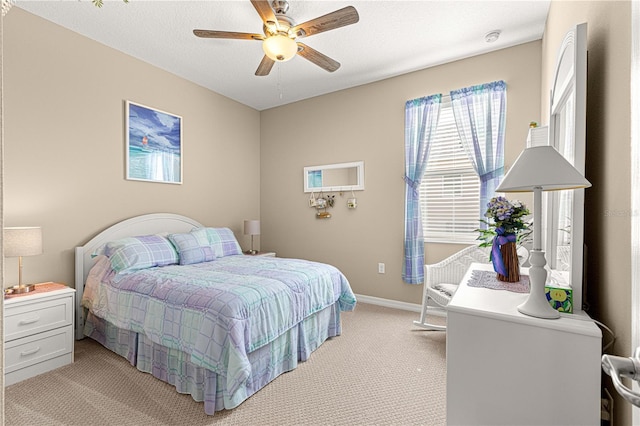 bedroom featuring a textured ceiling, light colored carpet, and ceiling fan