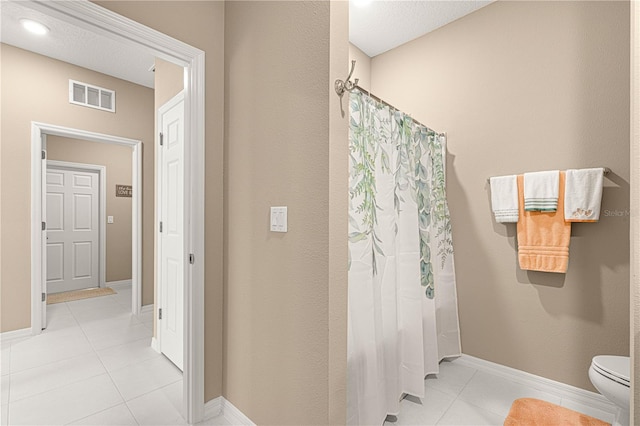 bathroom with tile patterned floors, toilet, and shower / bath combo