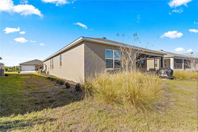 back of property with a garage and a lawn