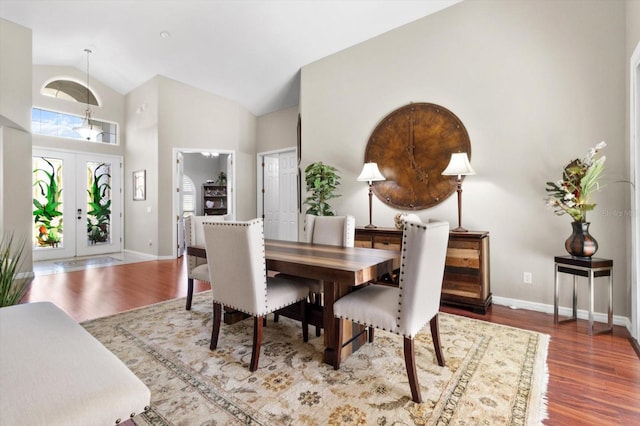 dining room featuring hardwood / wood-style flooring, high vaulted ceiling, and french doors