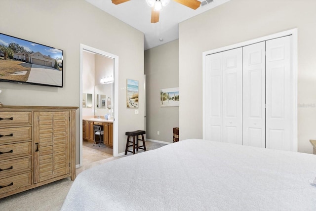 carpeted bedroom featuring ceiling fan, ensuite bathroom, and a closet