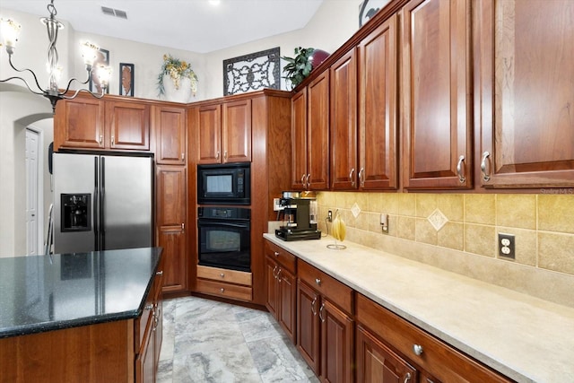 kitchen featuring hanging light fixtures, decorative backsplash, and black appliances