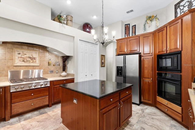 kitchen featuring an inviting chandelier, hanging light fixtures, a kitchen island, decorative backsplash, and black appliances