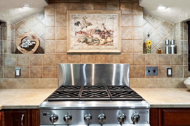 kitchen with backsplash, a textured ceiling, and stove