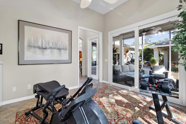 exercise room with tile patterned floors and ceiling fan