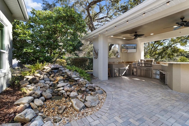 view of patio featuring area for grilling and ceiling fan