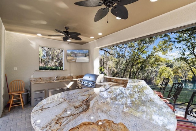 view of patio / terrace featuring exterior kitchen, area for grilling, an outdoor wet bar, and ceiling fan