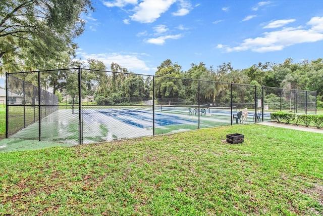 view of sport court with a yard