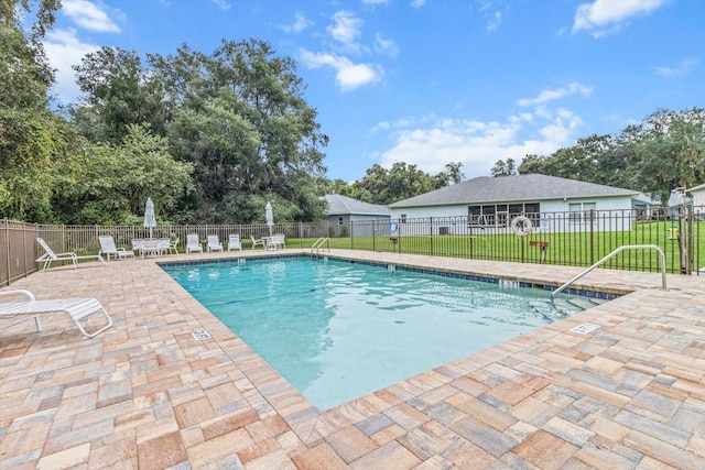 view of swimming pool with a yard and a patio