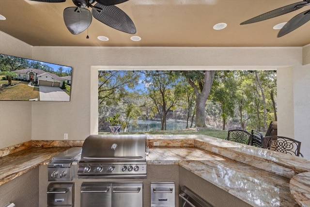 view of patio with a bar, ceiling fan, a grill, and exterior kitchen