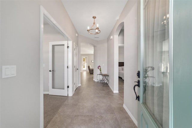 hallway with an inviting chandelier