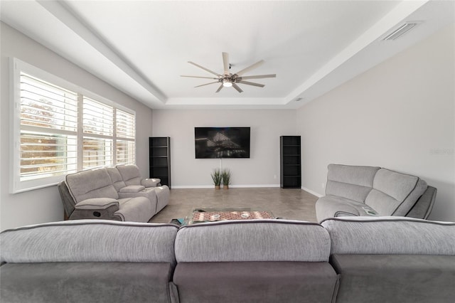 living room featuring ceiling fan and a tray ceiling