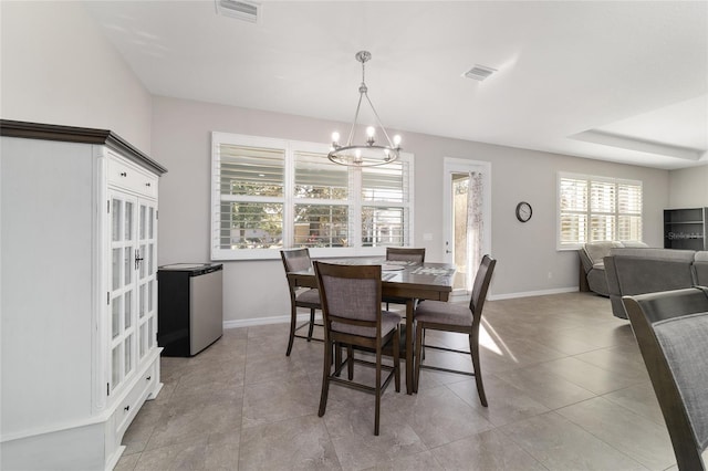 dining space featuring light tile patterned floors and a chandelier