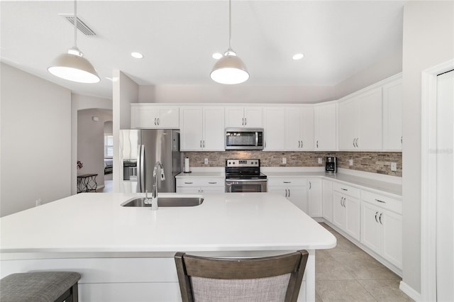 kitchen featuring hanging light fixtures, white cabinetry, appliances with stainless steel finishes, and sink