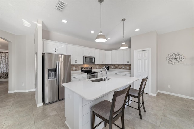 kitchen with sink, white cabinets, decorative backsplash, hanging light fixtures, and stainless steel appliances