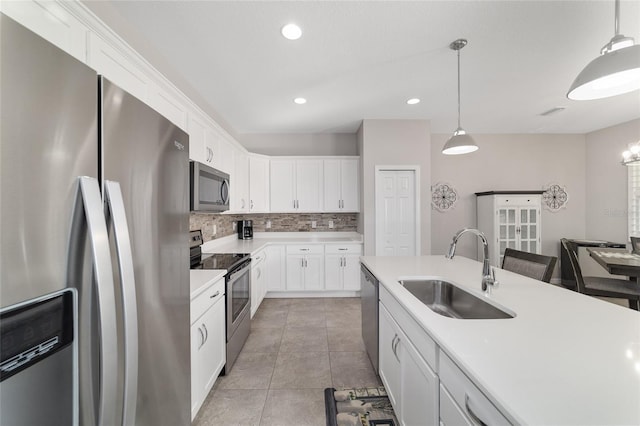 kitchen featuring sink, hanging light fixtures, stainless steel appliances, decorative backsplash, and white cabinets