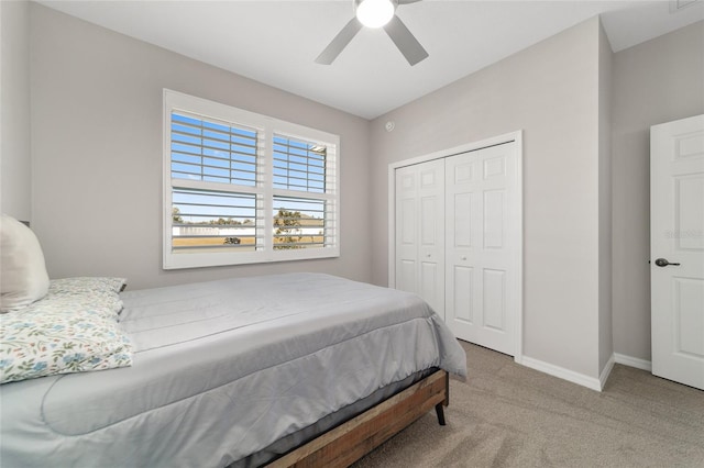 carpeted bedroom featuring ceiling fan and a closet