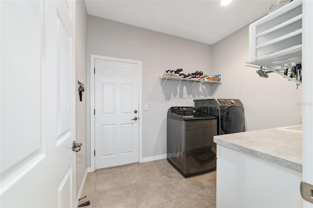 laundry room featuring washer and clothes dryer and light tile patterned flooring