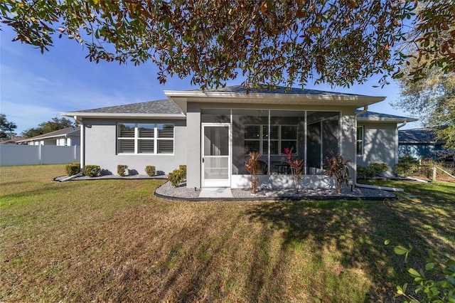 back of property with a yard and a sunroom