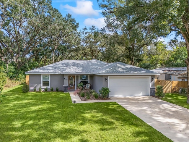 ranch-style home with fence, concrete driveway, a front yard, stucco siding, and an attached garage