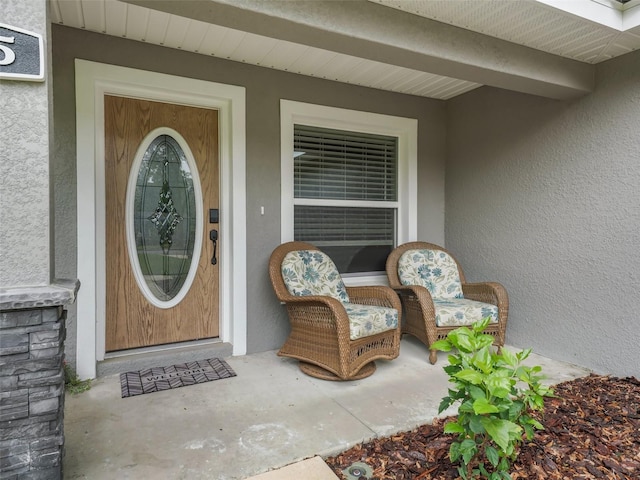 doorway to property featuring stucco siding