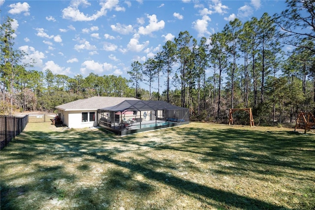 exterior space featuring a swimming pool, a lawn, a playground, and glass enclosure