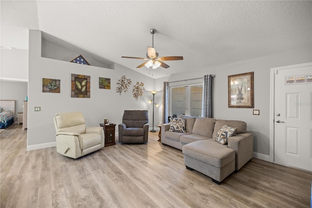 living room featuring lofted ceiling, ceiling fan, light hardwood / wood-style floors, and a textured ceiling