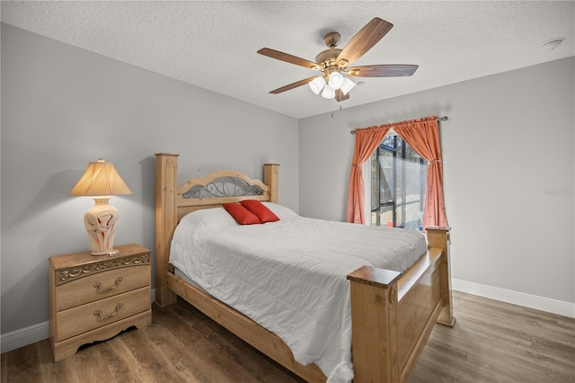 bedroom featuring dark hardwood / wood-style flooring, a textured ceiling, and ceiling fan