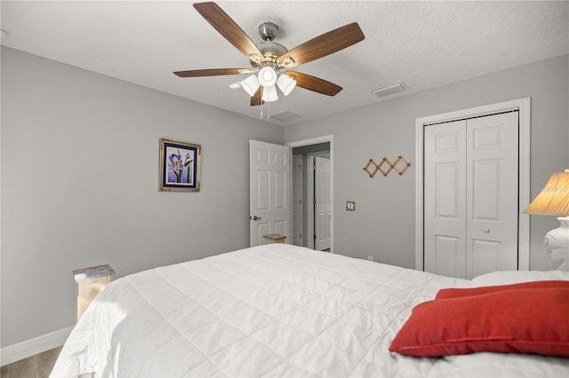 bedroom with ceiling fan, wood-type flooring, a closet, and a textured ceiling