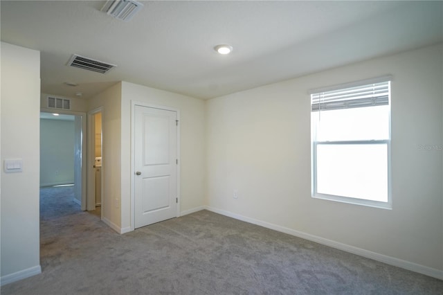 spare room featuring visible vents, baseboards, and carpet floors