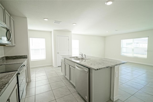 kitchen with visible vents, light tile patterned floors, a wealth of natural light, appliances with stainless steel finishes, and a sink