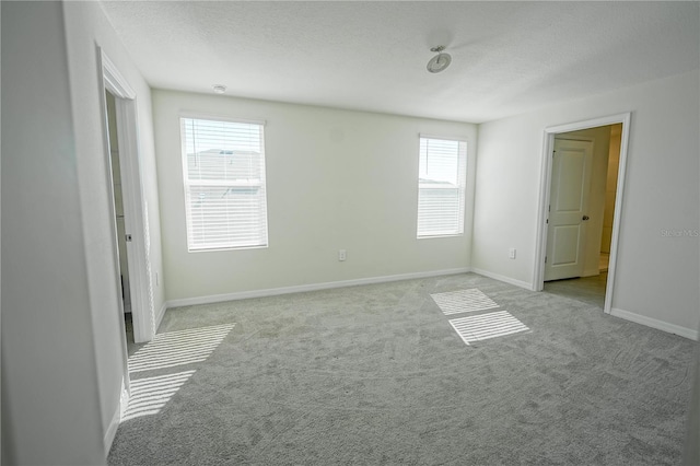 unfurnished bedroom featuring baseboards, a textured ceiling, and carpet flooring