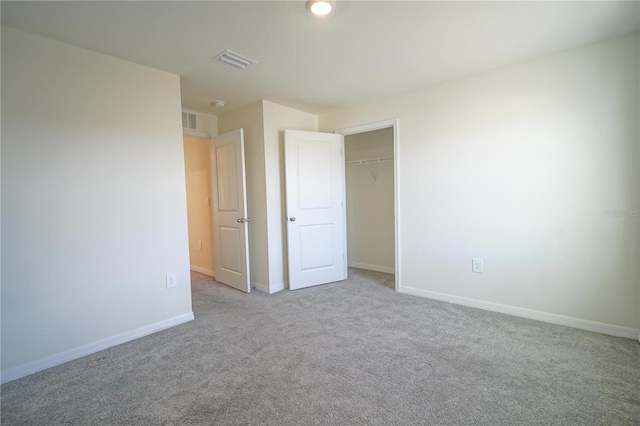 unfurnished bedroom with a closet, visible vents, carpet flooring, and baseboards