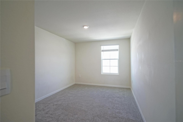 spare room featuring baseboards and carpet floors