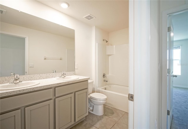 bathroom with tile patterned flooring, double vanity, toilet, and a sink