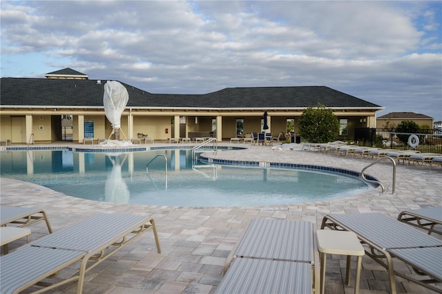 community pool featuring a patio and fence