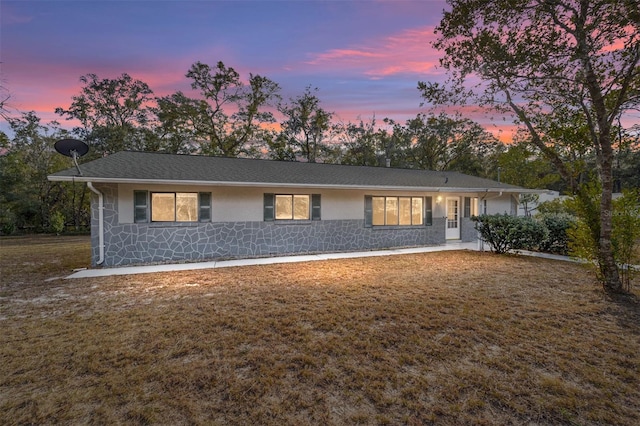 ranch-style home with a lawn