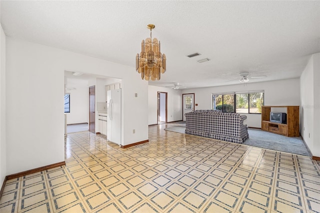 unfurnished living room with a fireplace, ceiling fan with notable chandelier, and a textured ceiling